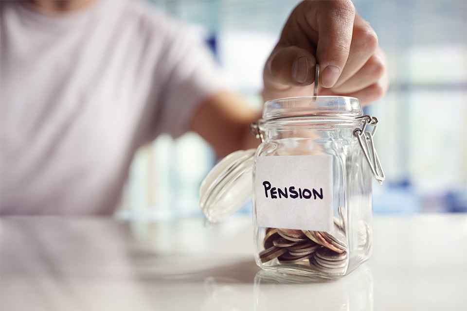 Person wirft Münzen in Glas mit Aufschrift Pension