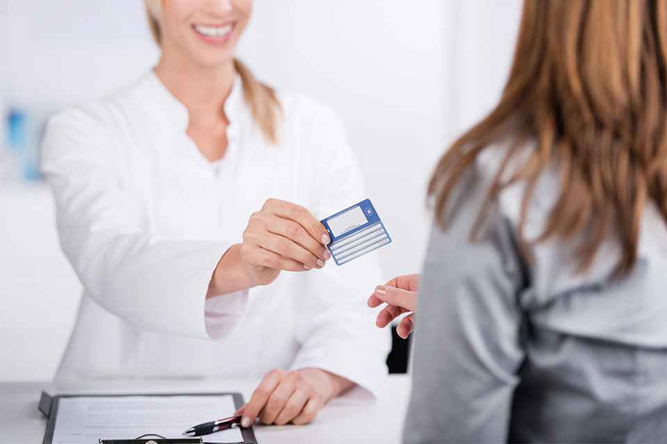 Patientin und Arzthelferin mit Versicherungskarte 